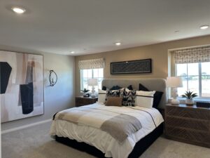 Primary bedroom with large windows and neutral decor in Plan 2218 at Catania at Citrine, Riverside, CA