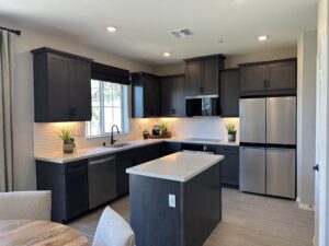 Kitchen with kitchen island, wood flooring, and stainless steel appliances in Plan 2218 at Catania at Citrine, Riverside, CA