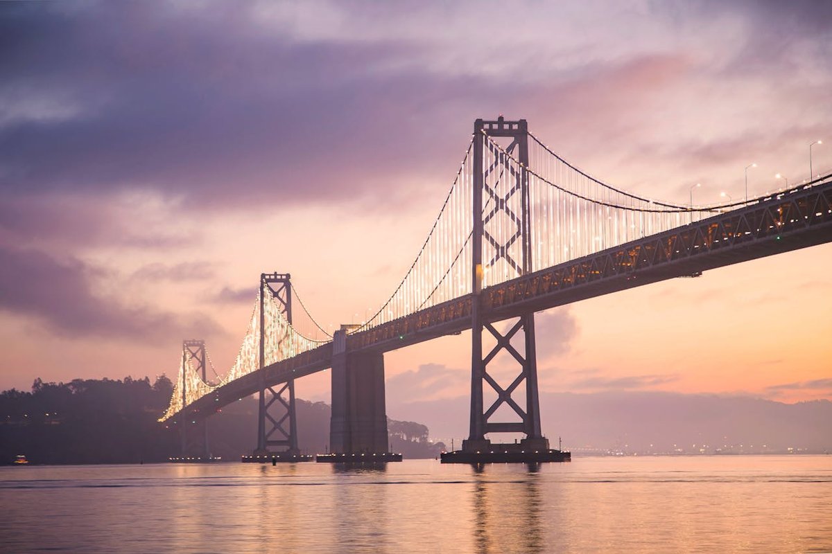 Bay Bridge at sunset in the San Francisco Bay Area, highlighting the region’s connection to technology, innovation, and luxury real estate growth.