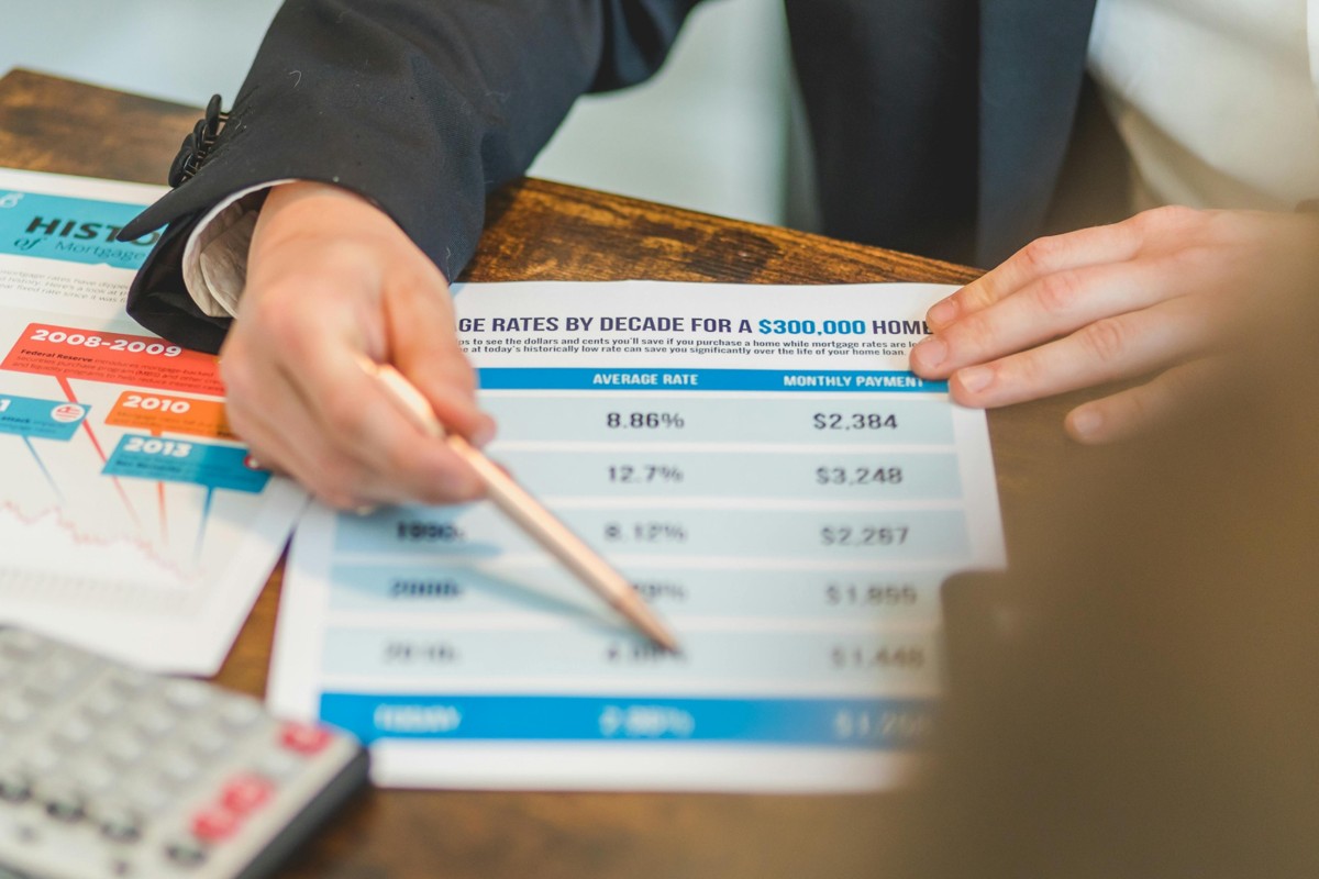 Person reviewing mortgage rate and monthly payment charts at a desk, illustrating rising borrowing costs and changing housing market conditions.